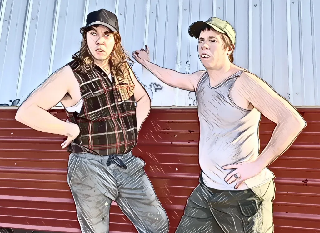 Buzz and Butch leaning on a red barn wall, hands on hips